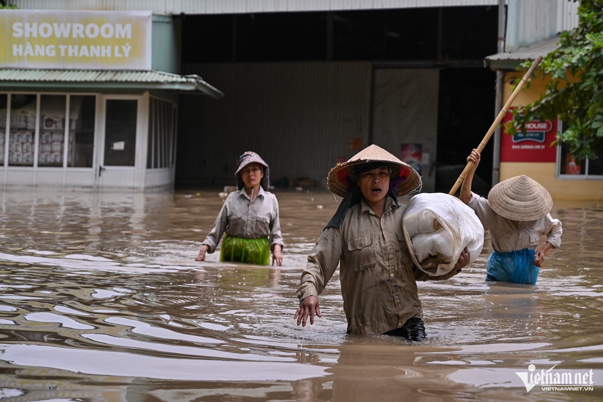 
Công nhân tại một nhà xưởng gần đó phải vớt đồ mang ra ngoài (Ảnh: Thạch Thảo - Nguyễn Hùng/Vietnamnet)
