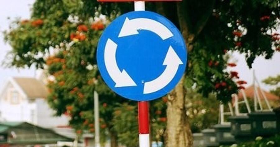 Trong Luật Giao thông, bùng binh có biển báo là R.303, hình tròn, nền xanh và ký hiệu màu trắng