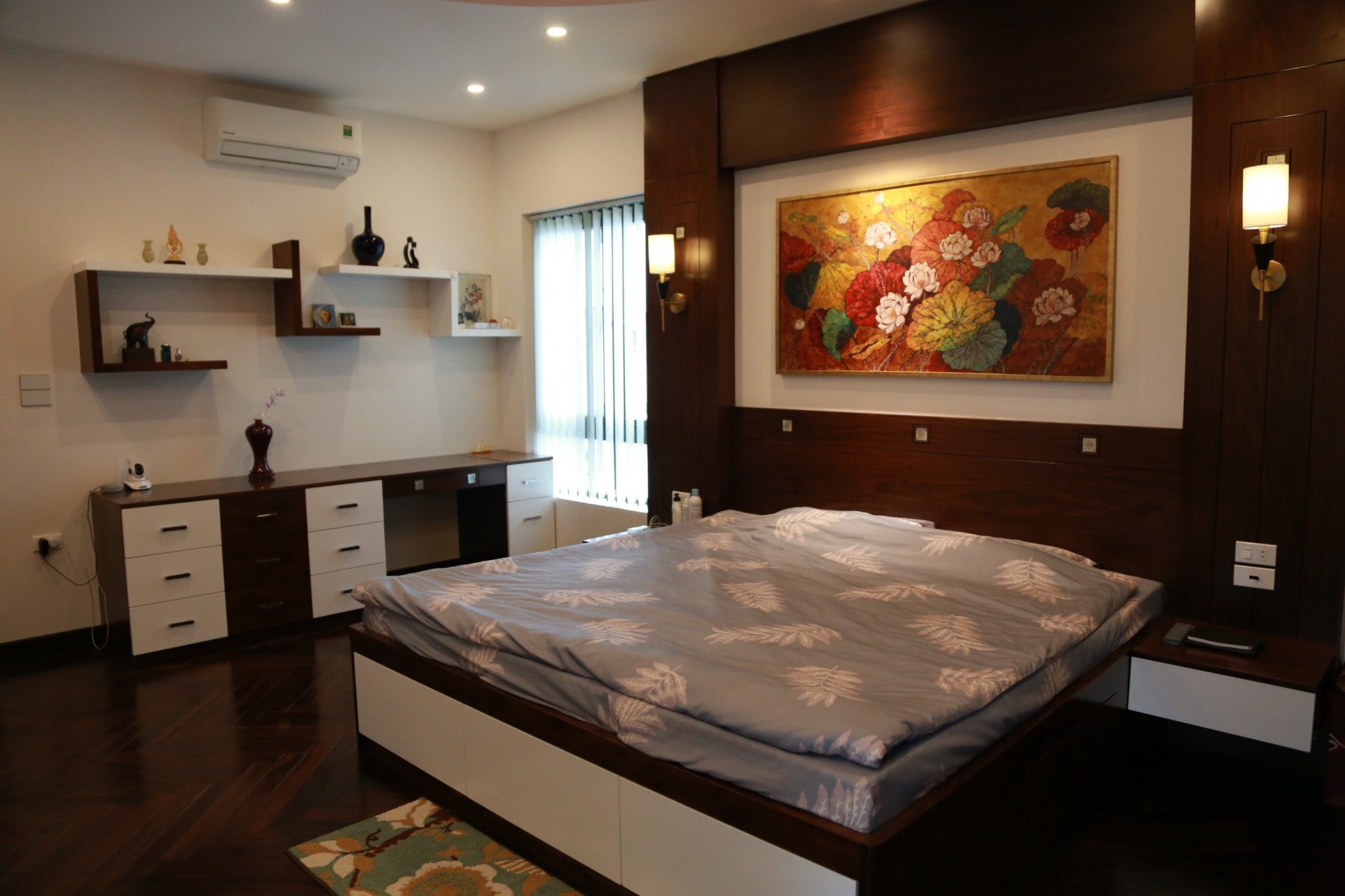 
Phòng ngủ của vợ chồng chủ nhà với sự tối giản, gọn hàng, điểm nhấn là bức tranh sơn mài hoa sen
