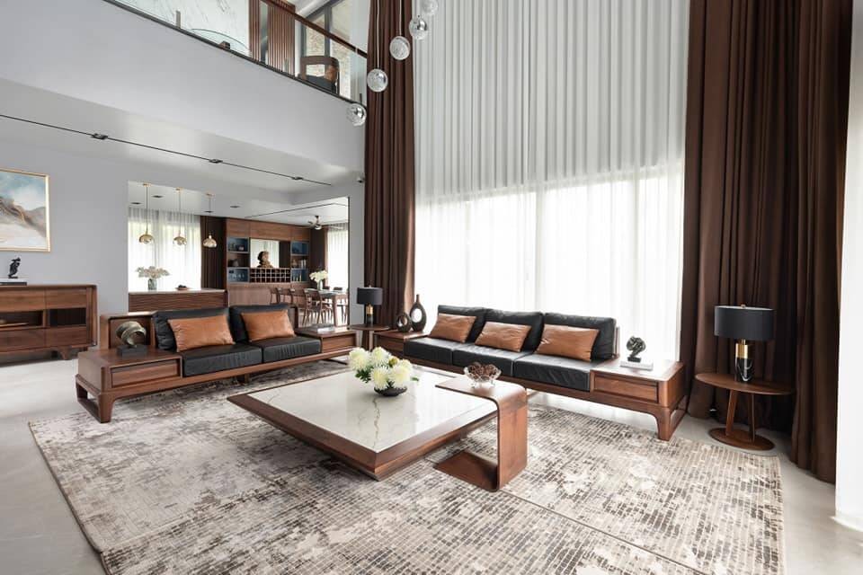 

Phòng khách được bày trí sang trọng và thoáng đãng nằm ở phần bên dưới khoảng thông tầng. Bộ sofa và bàn trà được làm bằng gỗ nâu giúp tô điểm thêm cho không gian
