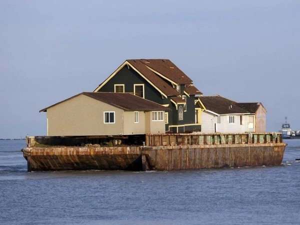 
Một sà lan biển với ba ngôi nhà được kéo đi để nhường chỗ cho một tòa nhà của Bill Gates. 
Nguồn ảnh: REUTERS/Ben Nelms
