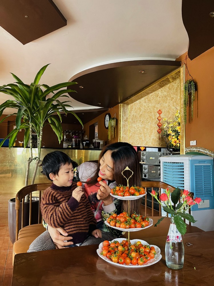 
Chị Oanh cùng con trai bên đĩa cà chua bi nhà trồng
