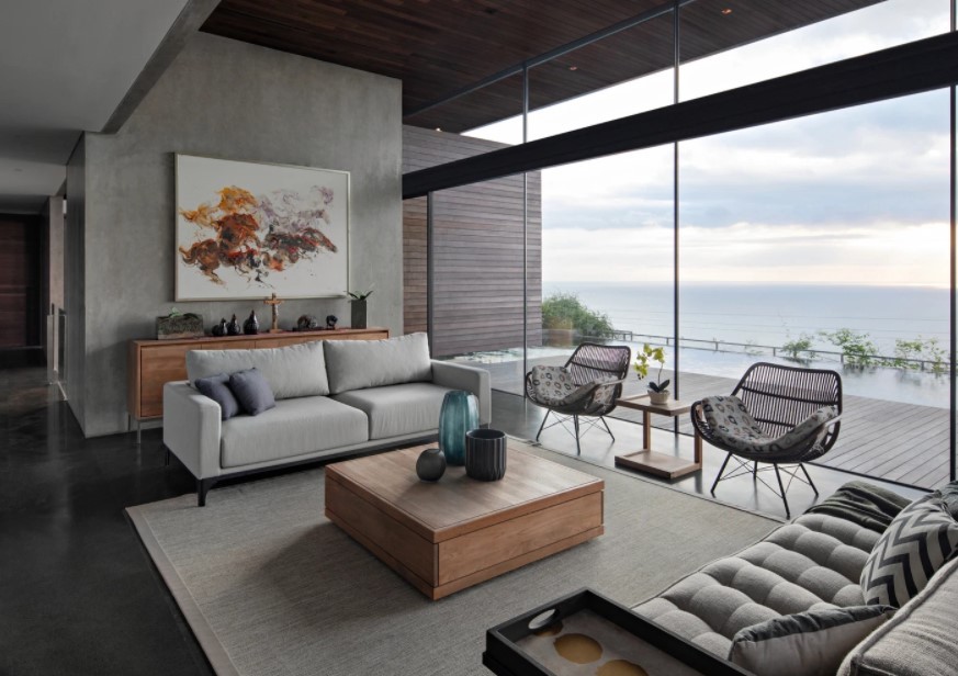 
Phòng khách có tưởng lớn bằng kính giúp người ngồi trong nhà nhìn ra được phía hồ bơi và biển ở phía xa
