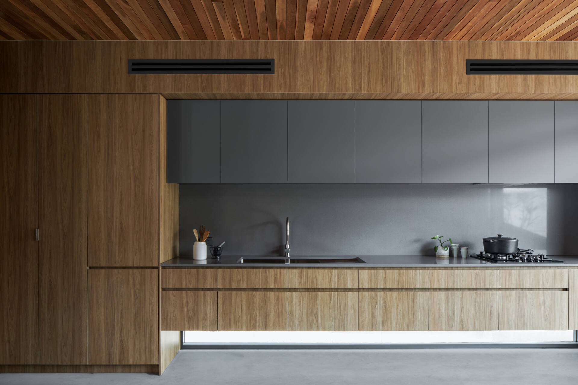 
Khu vực nhà bếp có nội thất được làm từ chất liệu gỗ mộc mạc kết hợp cùng với hợp kim tráng men màu xám trung tính, giúp cho không gian thêm sang trọng
