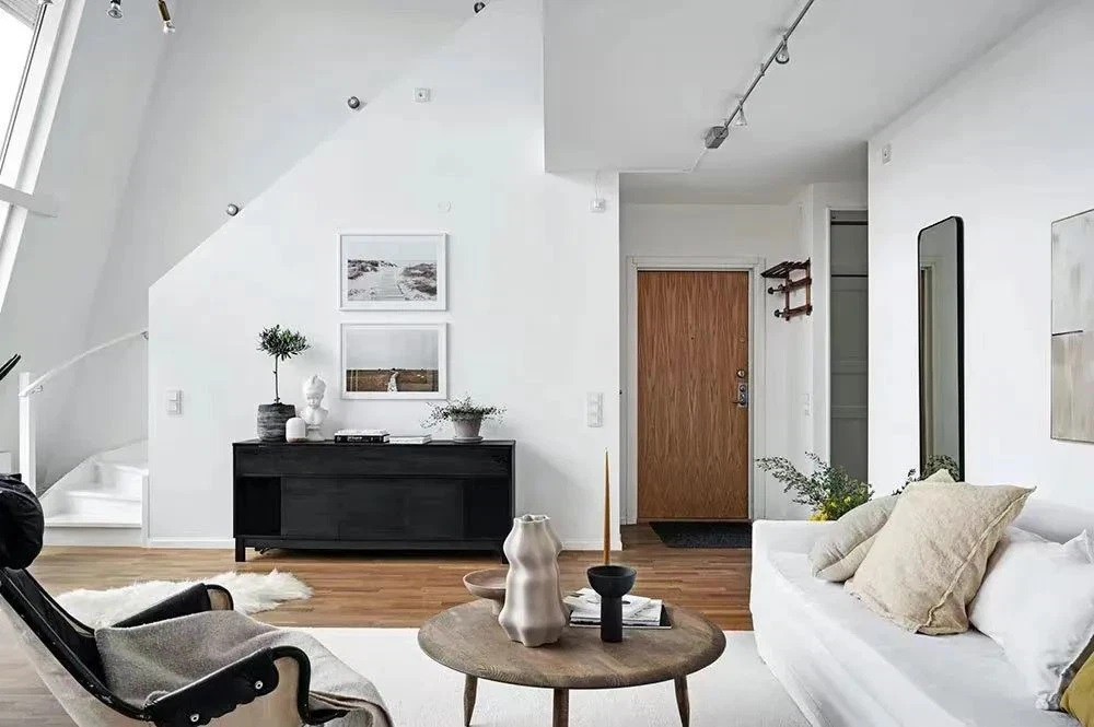 
Không gian phòng khách với màu sơn tường trắng sáng sủa kết hợp với kệ để đồ màu đen khiến cho căn phòng thêm cá tính hơn
