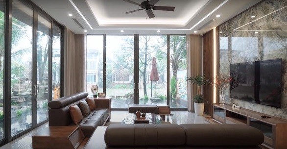 
Phòng khách rộng rãi, thoáng sáng tự nhiên nhờ hệ cửa kính kết hợp với nội thất làm từ gỗ óc chó tạo nên không gian đón khách lịch sự, nhẹ nhàng
