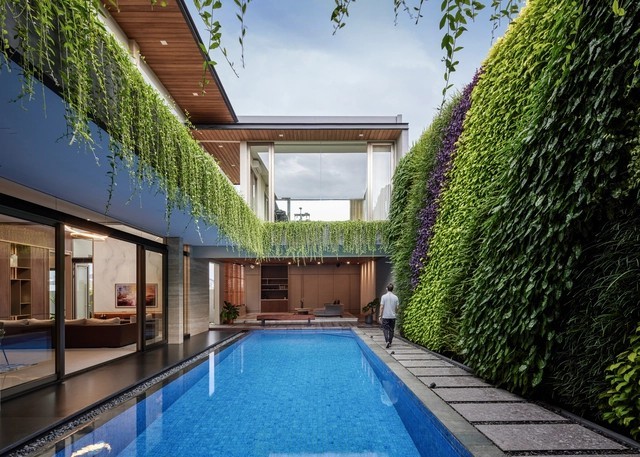 
Hồ bơi ngoài trời được thiết kế nằm cạnh tường bao và không gian sinh hoạt chung của gia đình, xung quanh tràn ngập cây xanh
