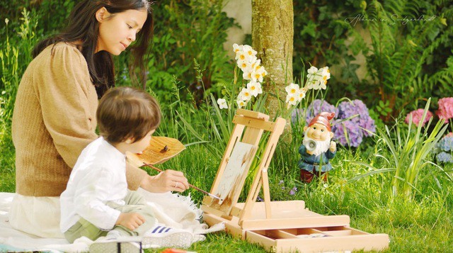 Hai mẹ con chị cùng nhau ngồi chơi trong khu vườn
