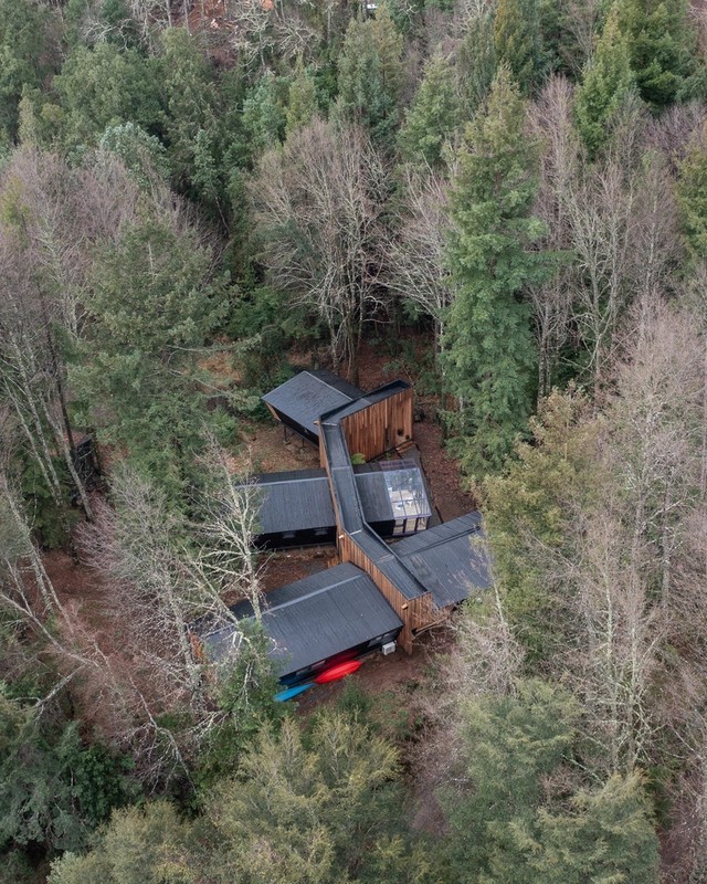 
Ngôi nhà có mái màu tối hài hòa với màu xanh của rừng cây
