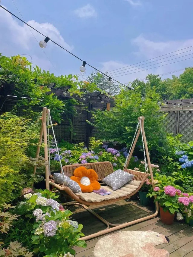 
Khu vườn tú cầu bày một chiếc xích đu, nơi Tiểu Hà nghỉ ngơi đọc sách, nghe nhạc, thư giãn, và khung cảnh mộng mơ được tạo nên bởi những chậu hoa cẩm tú cầu
