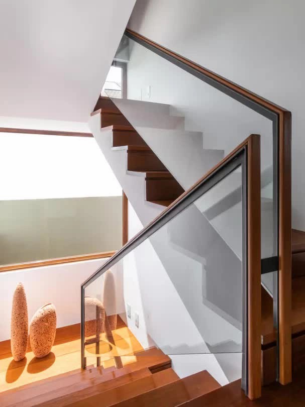 
Cầu thang dẫn lên khu vực tầng 2 được làm bằng kính với tay vịn là khung thép bọc gỗ
